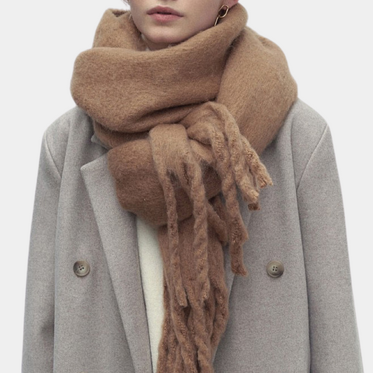 Frau mit beigem Wollschal und grauem Mantel, modisches Winteroutfit, warme Accessoires.