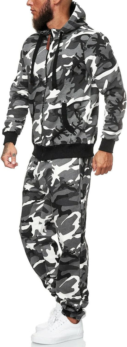 Mann im grauen Camouflage-Trainingsanzug mit Kapuze und weißen Sneakers, seitliche Ansicht.