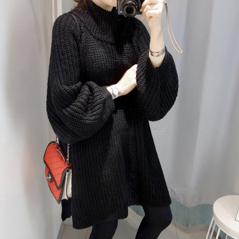 Frau in schwarzem Strickpullover mit Rollkragen, roter Umhängetasche, fotografiert im Spiegel.
