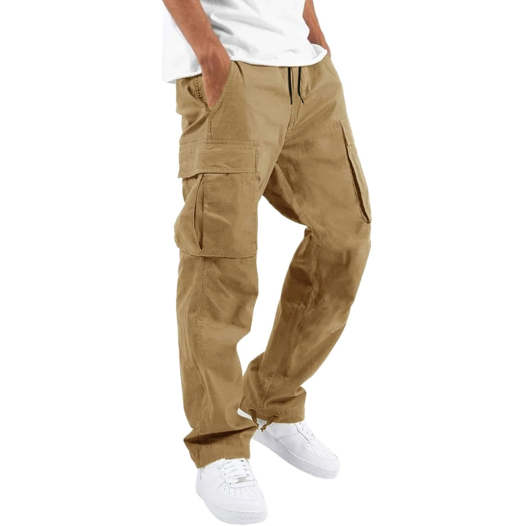 Man bär sandfärgade khakibyxor med flera fickor och dragsko i midjan, vit t-shirt och vita sneakers. 7