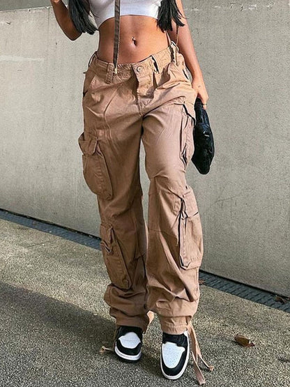 Frau in beigen Cargohosen und Sneakers, Streetwear-Mode, urbaner Stil, lässige Kleidung.