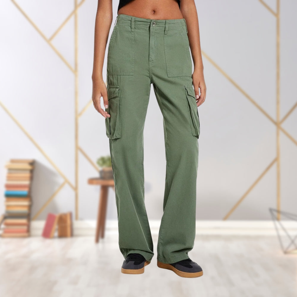 Frau in grüner Cargohose, weites Bein, Taschen, lässiger Stil, Innenraum, Mode.