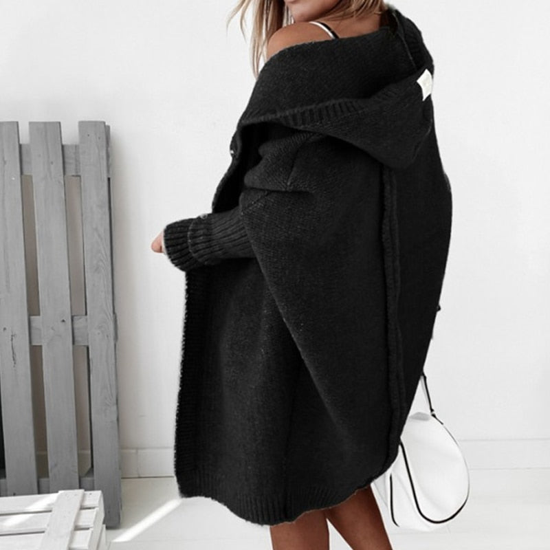 Frau trägt schwarzen Strick-Cardigan mit Kapuze, modisch, gemütlich, Herbstmode, Damenbekleidung.