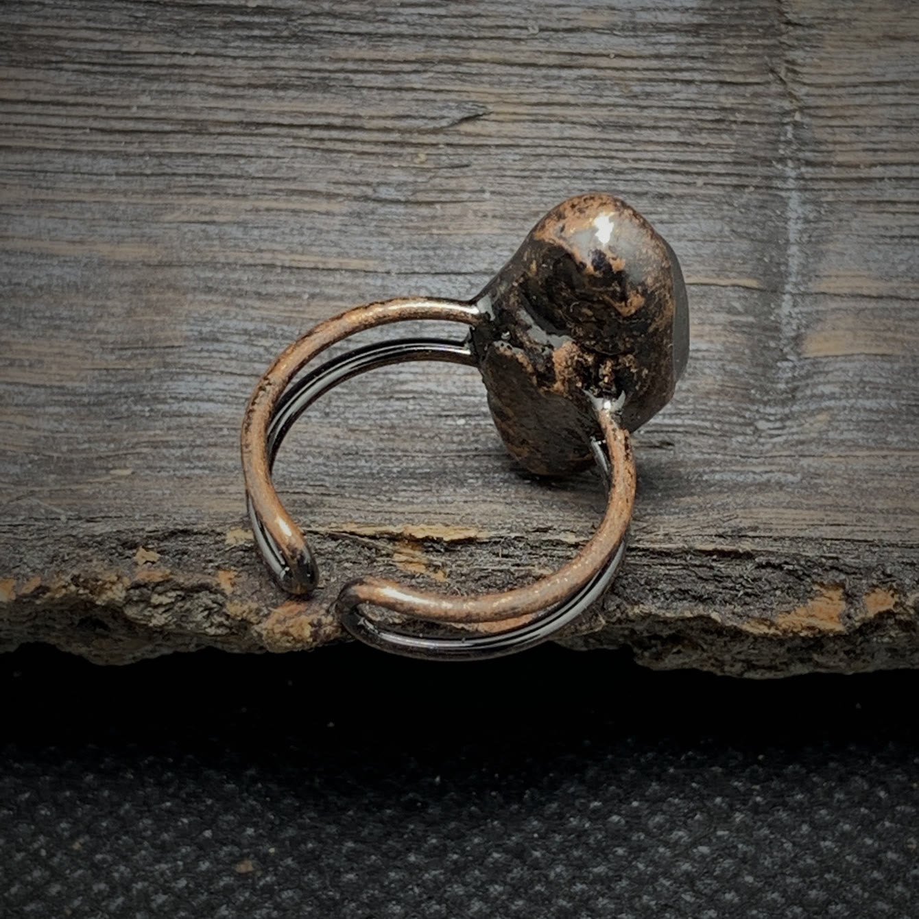 Silberring mit rustikalem, oxidiertem Design auf Holzoberfläche, handgefertigter Schmuck.