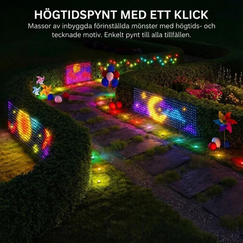 Trädgårdsgång i mörker med ljusgardiner på häckarna som visar färgglada mönster, månen och ballonger 7