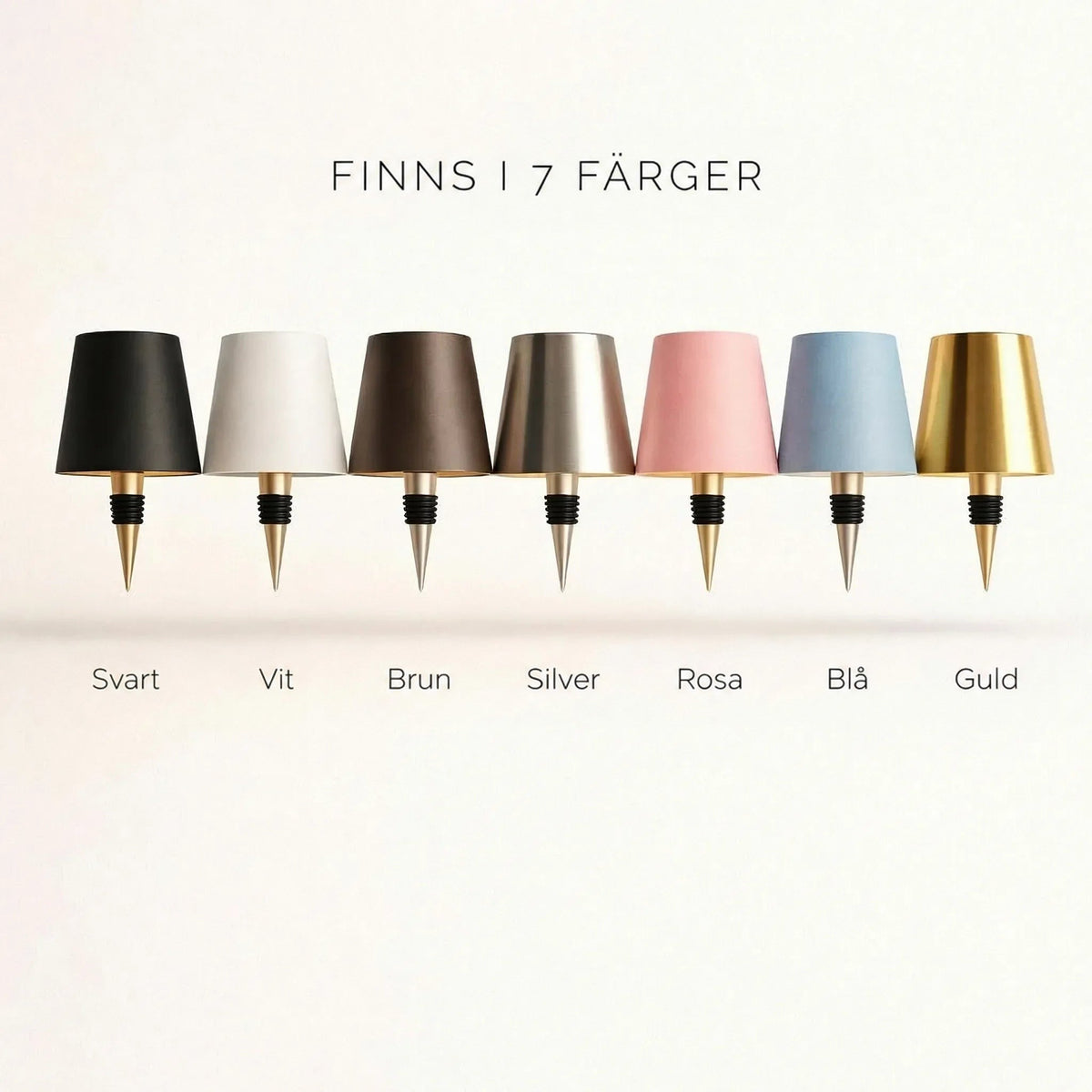Sju lampskärmar med flaskpropp i rad: svart, vit, brun, silver, rosa, blå och guld 3