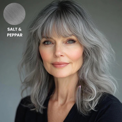 Äldre kvinna med vågigt grått hår med lugg i salt och peppar-nyans, med färgprov 9