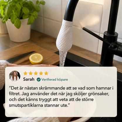 Vitt filter med mönstrad yta på en svart kran över en svart diskho, med citron och basilika bakom. 7