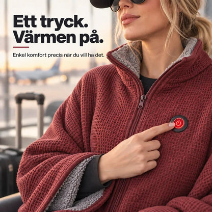 Närbild på bröstet av röd poncho där ett finger trycker på den röda strömknappen 9