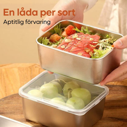 Händer håller en burk med sallad och fisk ovanför en burk med druvor under genomskinligt lock på ett träbord. 5