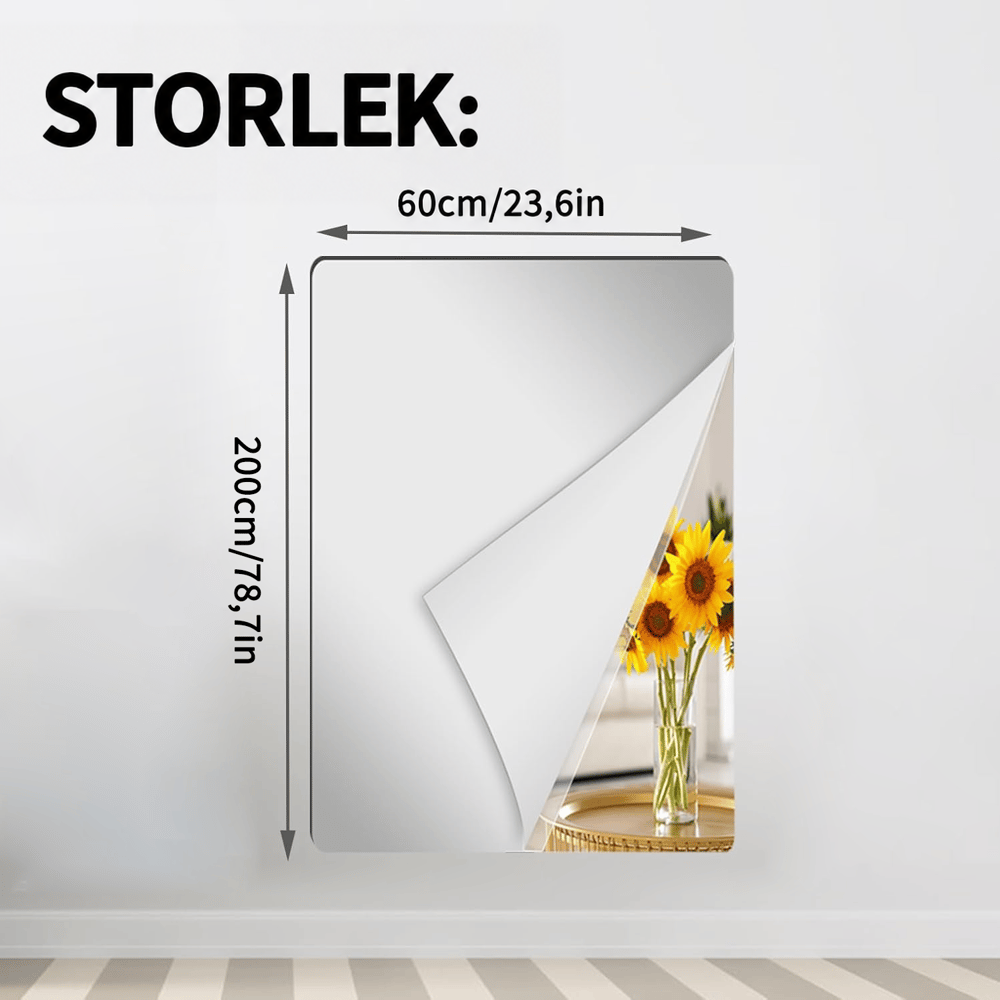 Högt rektangulärt spegelark i det bredare formatet på en vit vägg, uppvikt hörn med solrosor och måttpilar för längd och bredd. 15