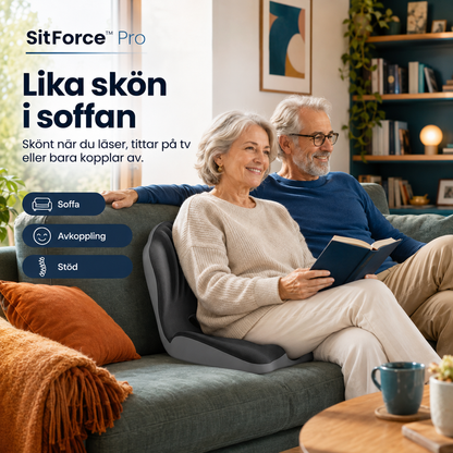 Äldre par i soffan, kvinnan med sittdynan bakom ryggen medan hon läser en bok 2