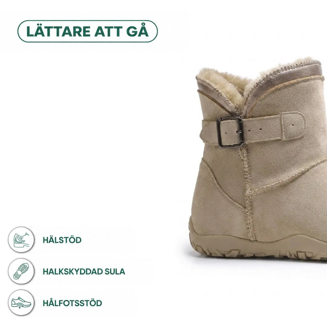 Beige känga med spänne i närbild, med ikoner för hälstöd, halkfri sula och hålfotsstöd 4