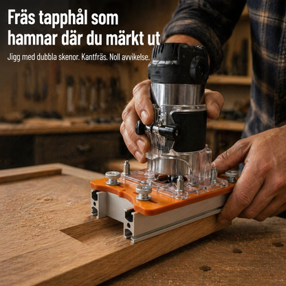 Snickare kantfräser en tapphålsurtagning med mallen, en orange platta med två aluminiumskenor fastspända över ett träämne i verkstaden. 1