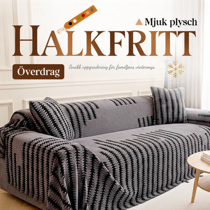Grått mjukt sofföverdrag med svarta sicksackränder draperat över en soffa, med kuddar i matchande mönster 1