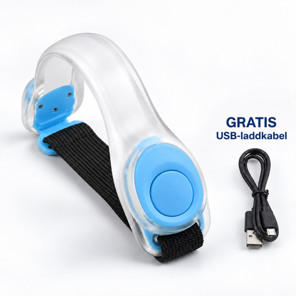 Genomskinligt armband med blå detaljer och svart elastiskt band, med USB-laddsladd bredvid 10