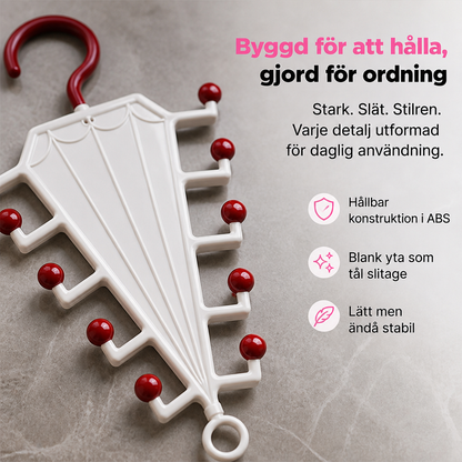 Närbild på vit galgstång med mörkröda kulspetsar och krok, liggande på en grå stenyta 3
