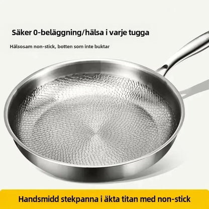 Närbild på pannans hamrade botten snett uppifrån, med informationstext om beläggningsfri och nonstick yta ovanpå och under bilden. 5
