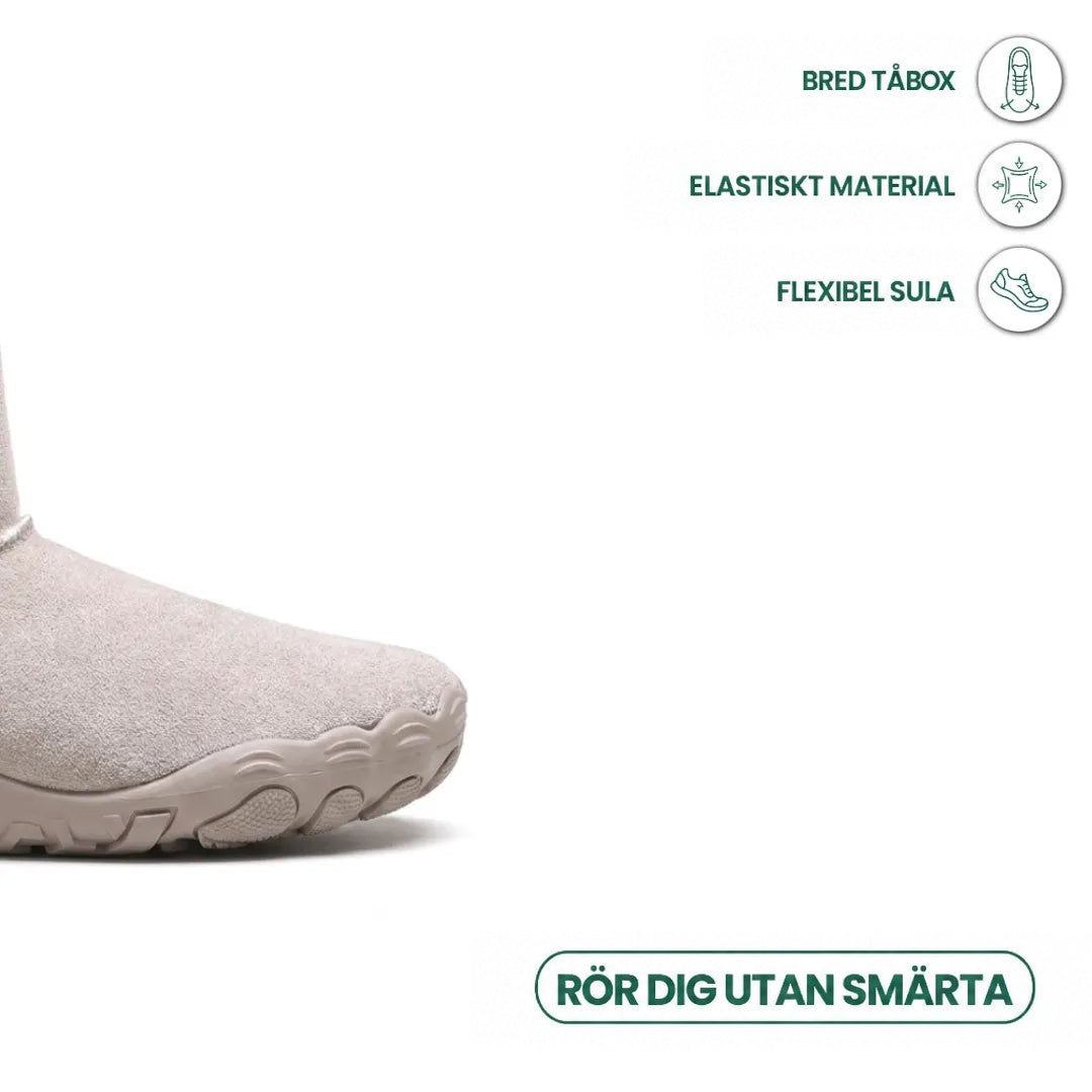 Närbild på tån av ljusgrå känga med bred tåbox och flexibel sula, med ikoner 32