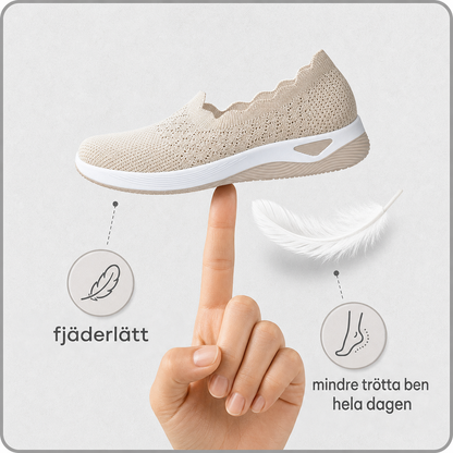 Beige sko balanserad på ett fingertopp bredvid en fjäder, för att visa hur lätt den är 3