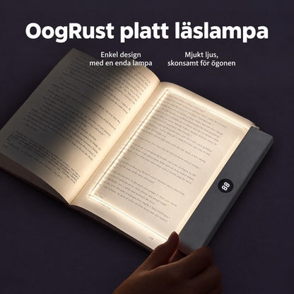 Handen håller en tänd platt läslampa med timerdisplay över sidan i en uppslagen bok 1
