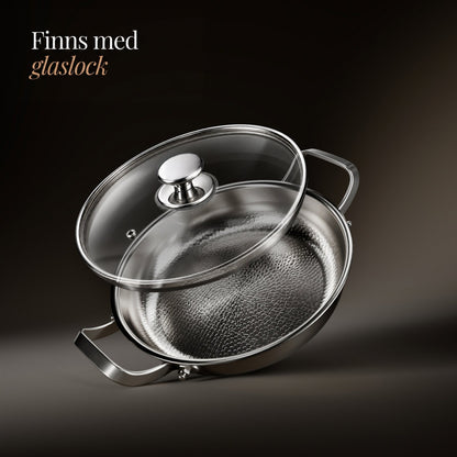 Pannan med genomskinligt glaslock och blank knopp som lyfts upp snett över kärlet, mot mörk bakgrund. 3