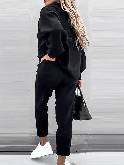 Frau in schwarzem Jogginganzug mit Tasche und weißen Sneakers, lässige Mode, Rückansicht.