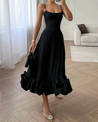 Frau in elegantem schwarzem Abendkleid mit Rüschen, modisch, stilvoll, Wohnzimmer.