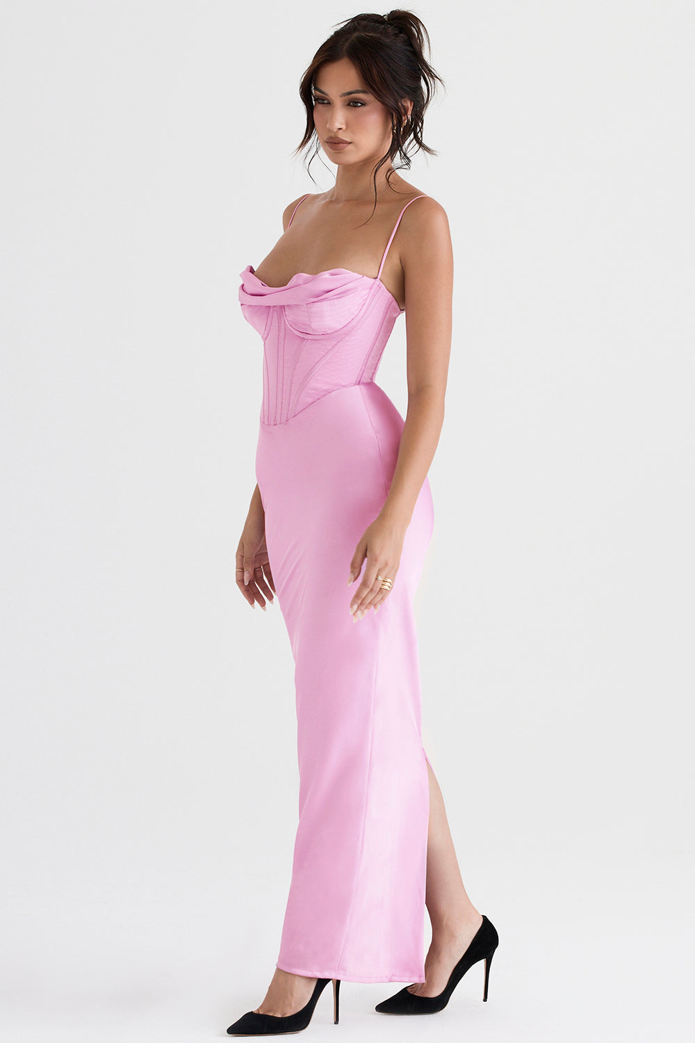Frau im rosa Abendkleid mit Korsett-Design, Spaghettiträger, schwarze High Heels.