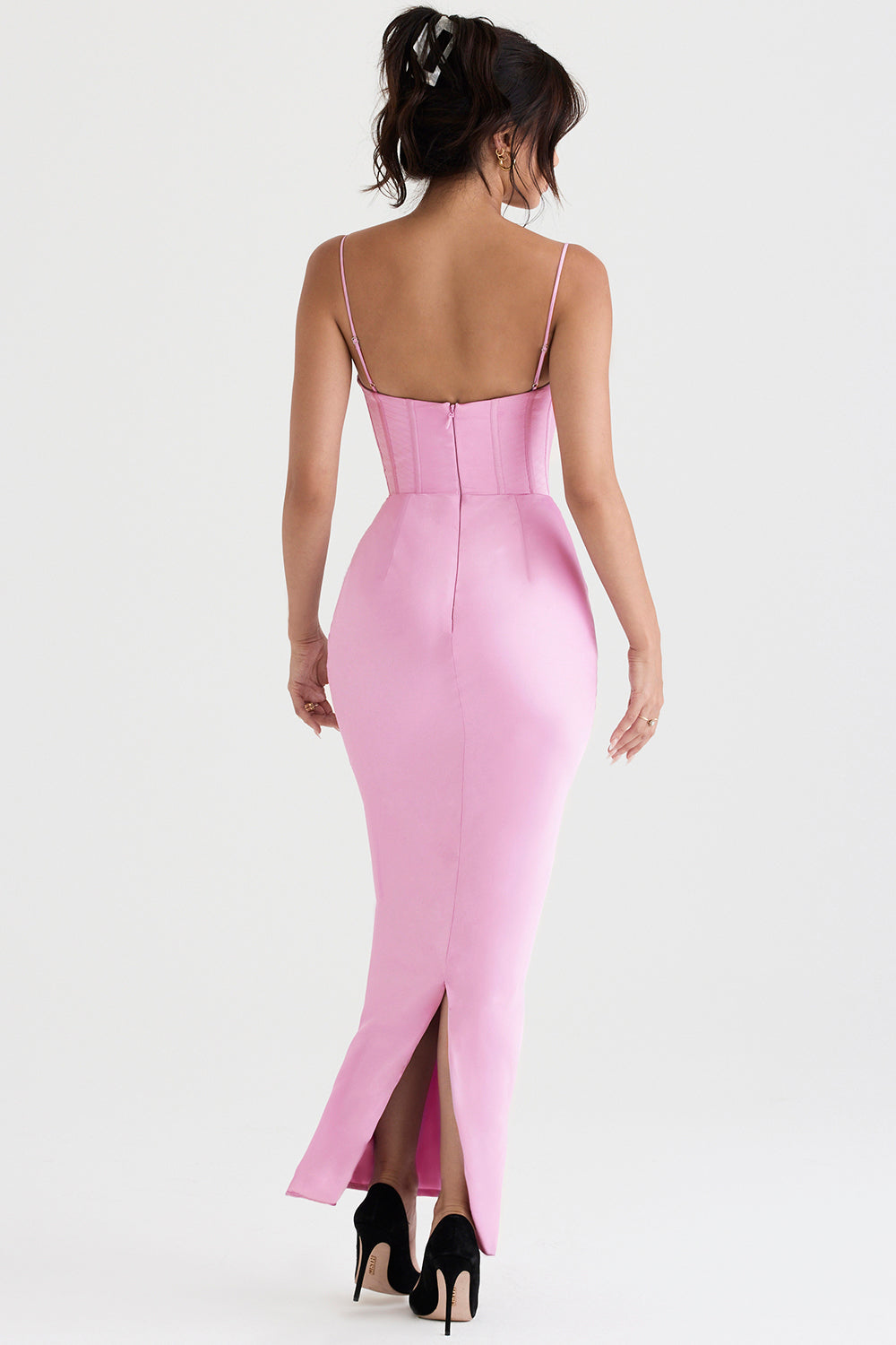 Frau in rosa Abendkleid mit Spaghettiträgern und Rückenausschnitt, elegante Mode.