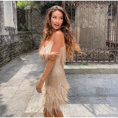 Frau in goldenem Paillettenkleid mit Fransen, draußen, modisch, elegantes Cocktailkleid.