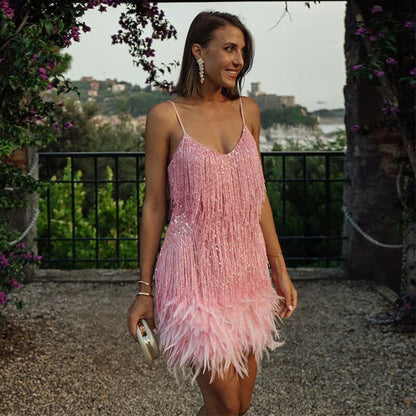 Frau im rosa Cocktailkleid mit Fransen und Federn, elegantes Abendoutfit, draußen bei Sonnenuntergang.