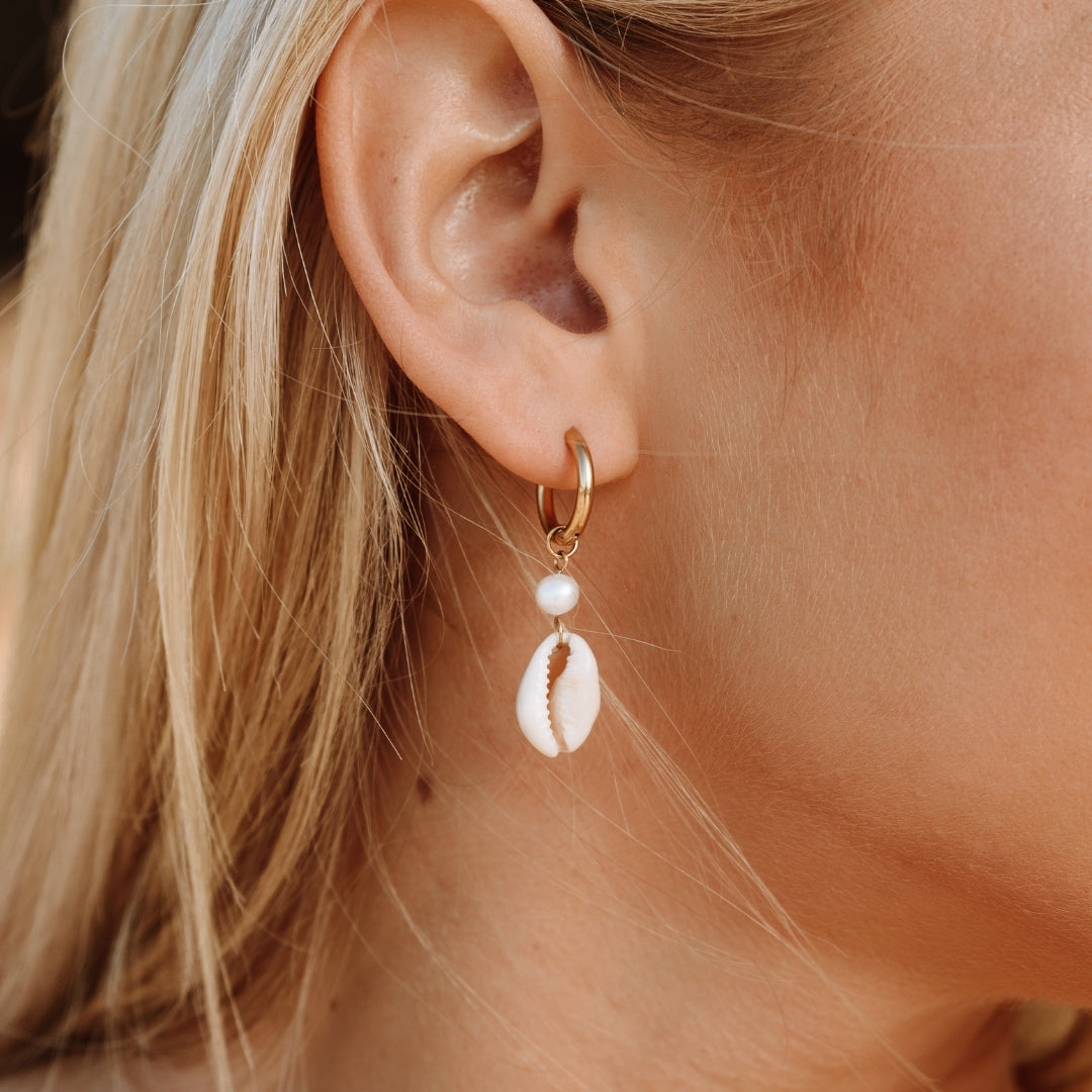 Goldene Ohrringe mit Kauri-Muschel und Perle, modischer Schmuck für Damen.