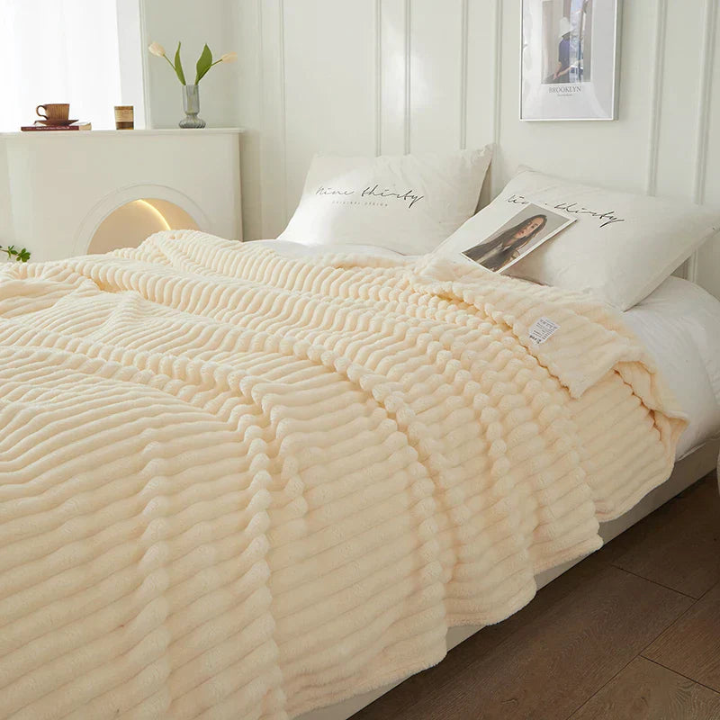 Cremefarbene Strickdecke auf Bett, weiche Textur, gemütliches Schlafzimmer, moderne Einrichtung.