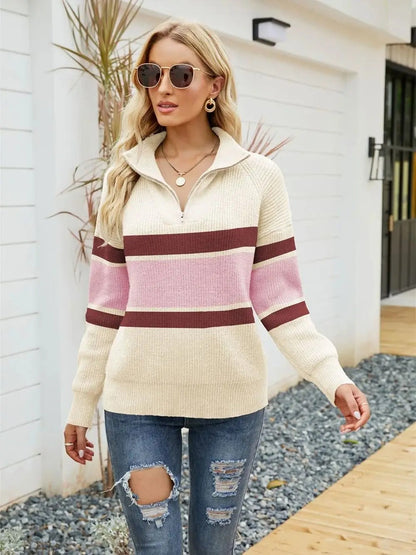 Frau in cremeweißem Strickpullover mit rosa Streifen, Sonnenbrille, zerrissene Jeans, draußen.