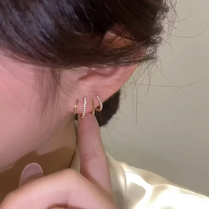 Örat sett från sidan med fyra tunna klor, varannan med glittrande stenar, och ett finger bredvid 3