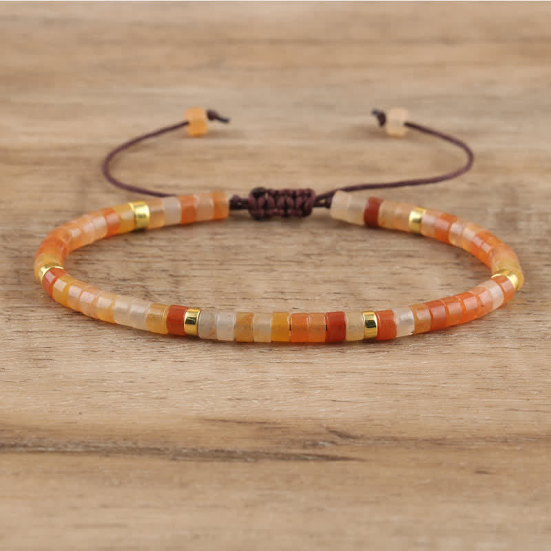 Armband aus bunten Glasperlen, verstellbar, handgefertigt, auf Holzoberfläche.