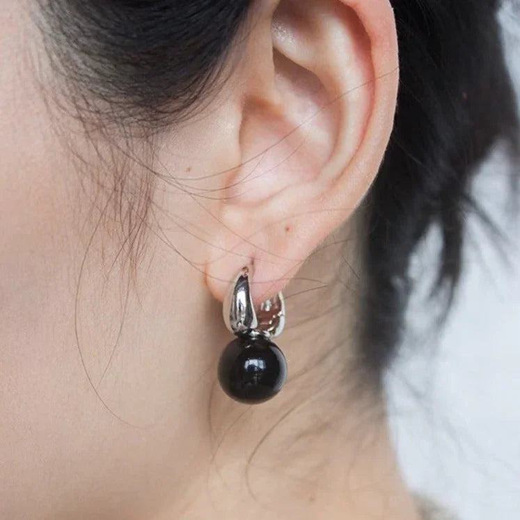 Silberne Ohrringe mit schwarzem Anhänger, eleganter Schmuck für Damen, modisches Accessoire.