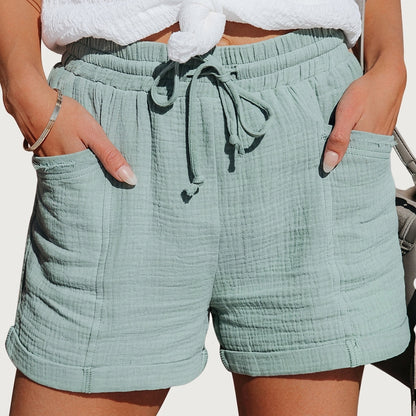 Samma shorts i dämpad mintgrön ton, buret av modell med händerna i fickorna och knytsnöre i midjan. 5