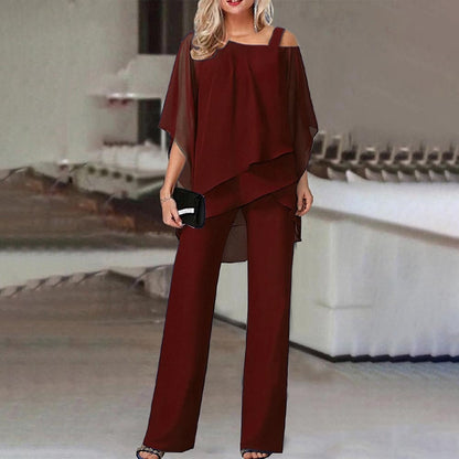 Frau in eleganter, weinroter Chiffon-Hose und Tunika, Abendmode, schulterfrei, mit Clutch.