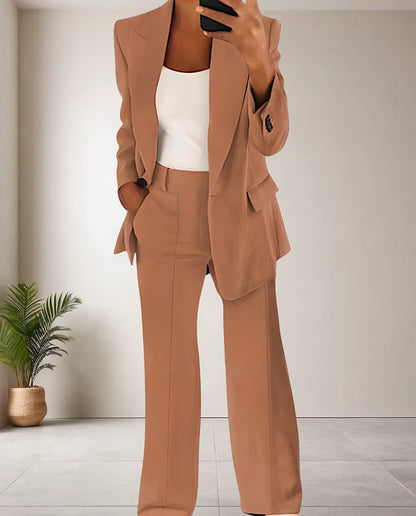 Frau im braunen Anzug mit weißem Top, moderne Büro-Outfit, minimalistische Einrichtung.