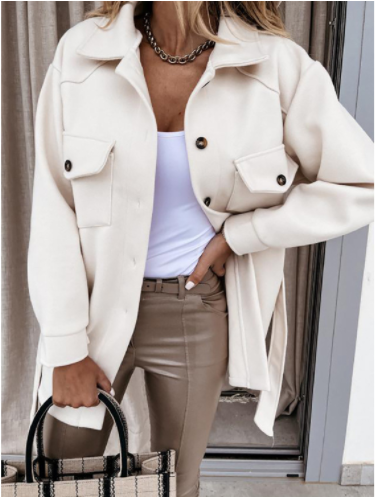 Frau in cremefarbener Jacke, weißem Top, beigen Hosen, hält karierte Tasche, modisch, elegant.