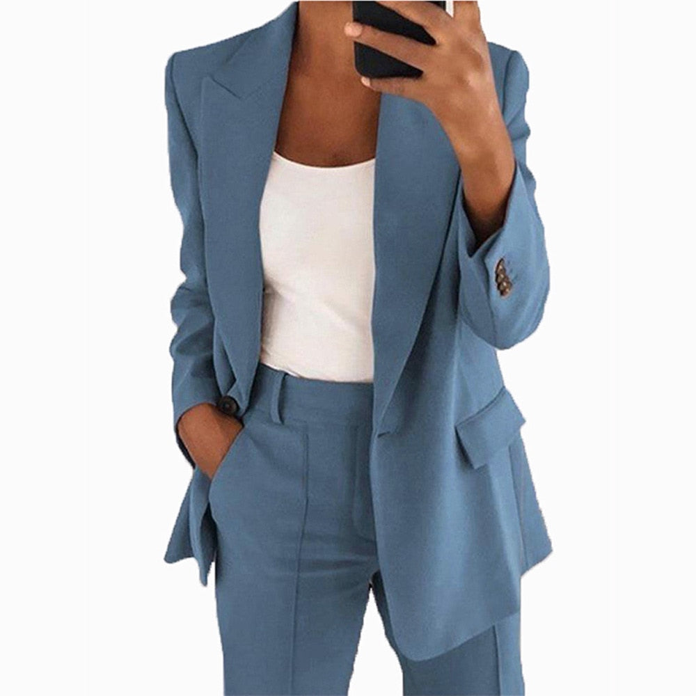 Frau in blauem Anzug mit weißem Top, Businessmode, eleganter Damenanzug, Bürooutfit.