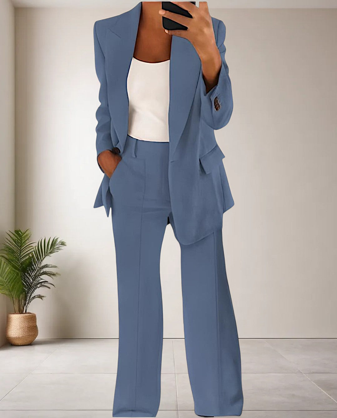 Frau im blauen Hosenanzug, weißes Top, modernes Büro-Outfit, elegantes Design.