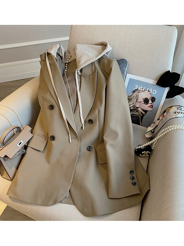 Beiger Damenblazer mit Kapuze auf Sessel, elegantes Design, Modeaccessoires, modernes Outfit.