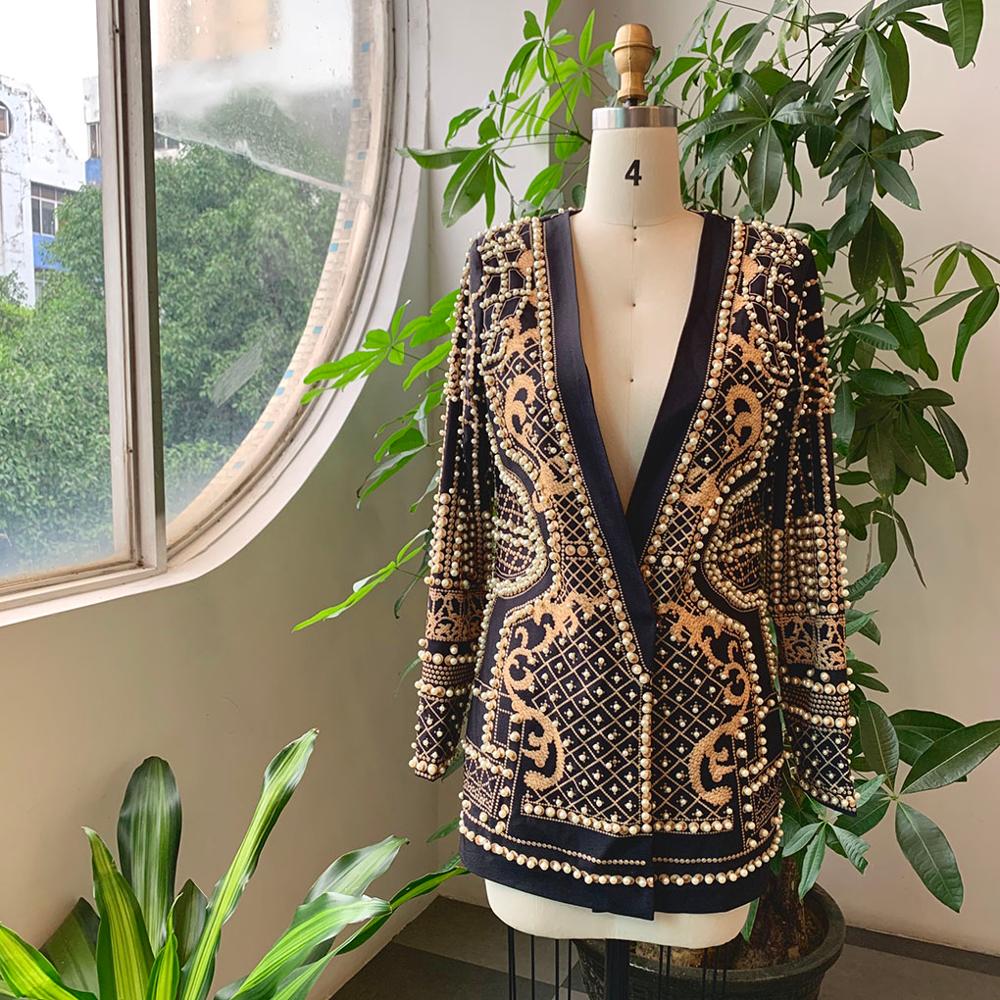 Schwarzer Blazer mit goldenen Verzierungen auf Schneiderpuppe, elegantes Design, Damenmode.