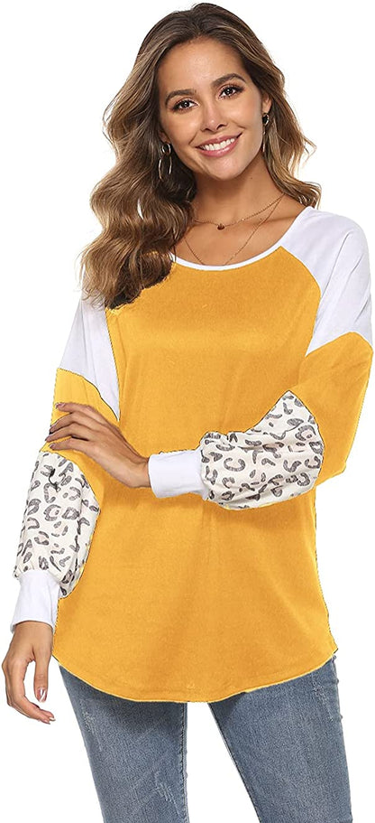 Frau in gelbem Langarmshirt mit Leopardenmuster-Ärmeln, lächelnd, modisch, Freizeitkleidung.