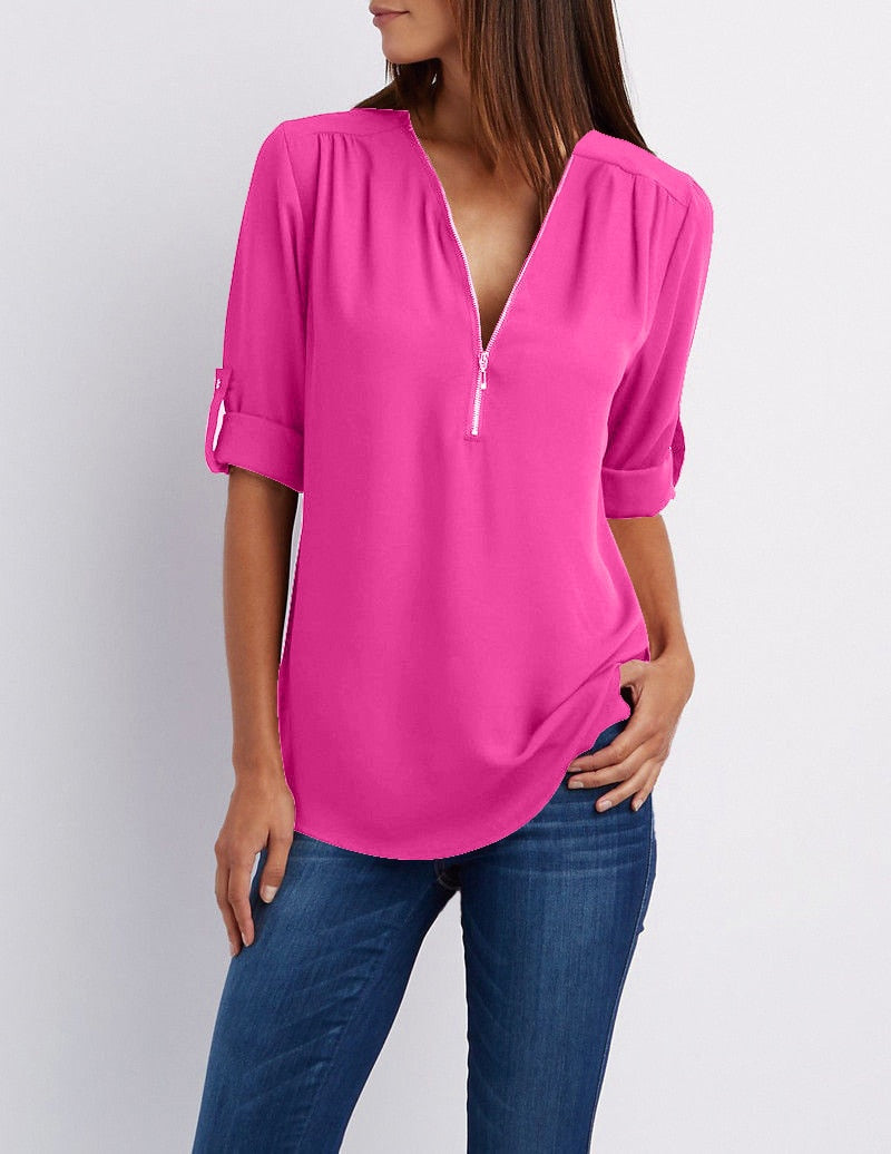 Frau in pinker Bluse mit Reißverschluss, 3/4-Ärmel, lässig, modisch, Damenmode, Jeans.