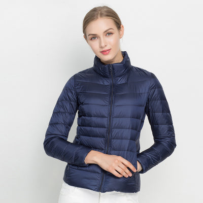 Frau in blauer Daunenjacke, Stehkragen, Reißverschluss, modisch, warm, Winterbekleidung.