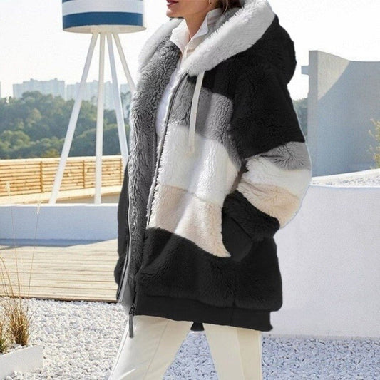 Frau in gestreiftem Kunstpelzmantel mit Kapuze, schwarz-weiß, modisch, warm, Winterbekleidung.